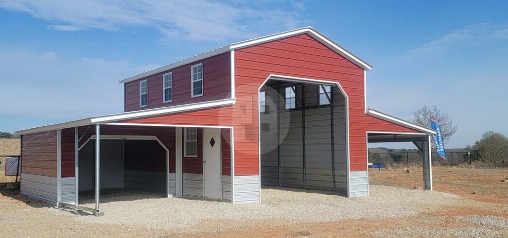 Two-storey metal barn with a red upper level, dormer windows, an open centre bay and lean-to covers on both sides