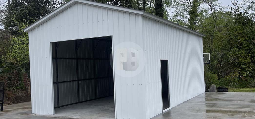 Single-bay white metal garage on a concrete slab, open bay opening and a narrow walk-in doorway at the side